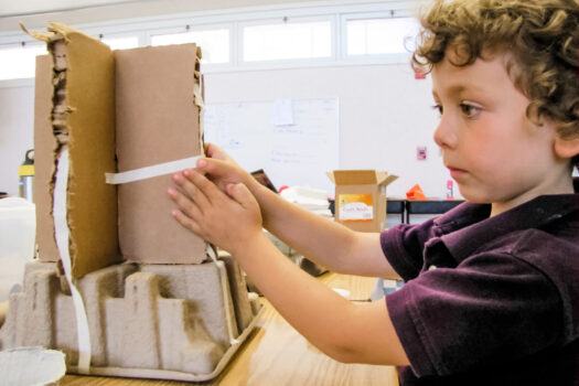 Boy Taping Cardboard Tower