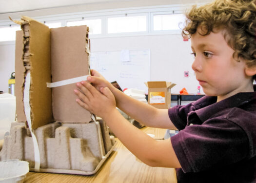 Boy Taping Cardboard Tower