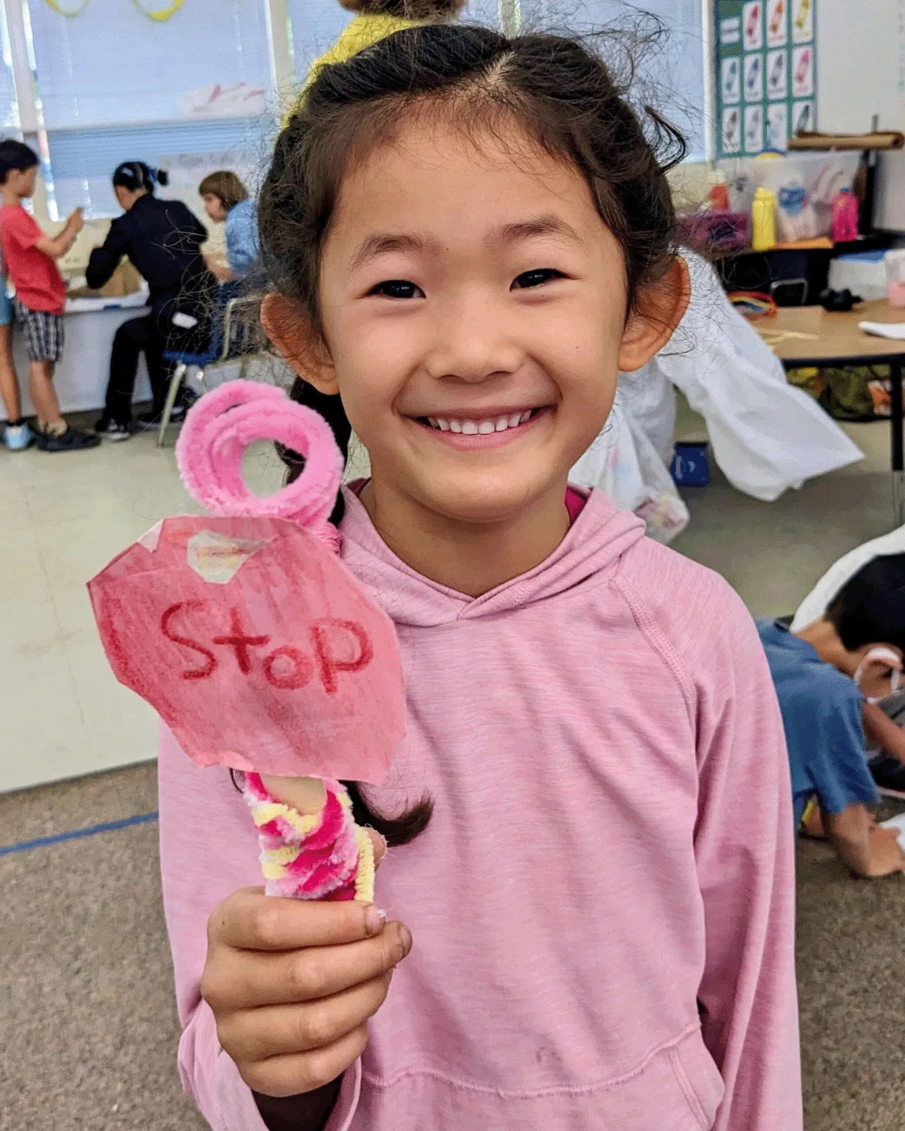 A student holding up the Stop sign she made in class